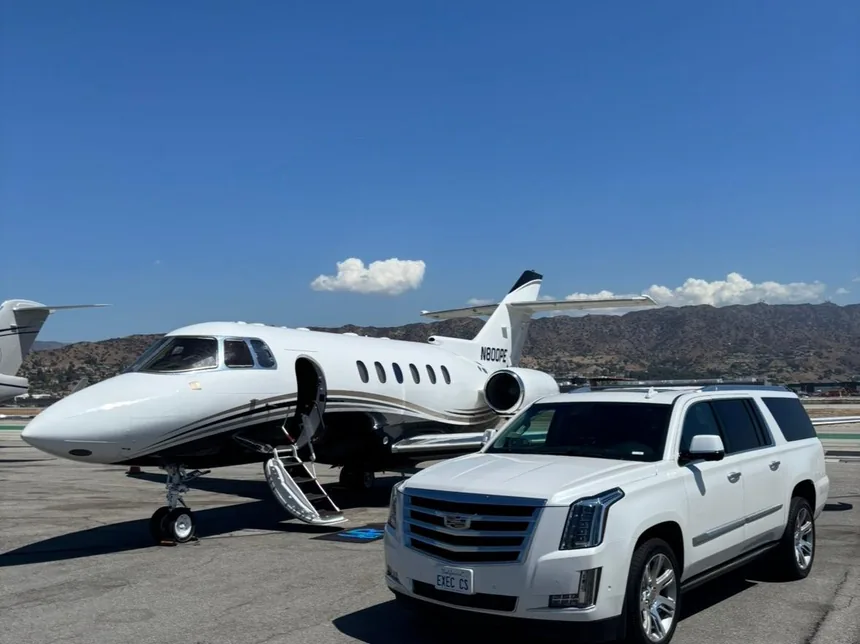 White Cadillac Escalade ESV from Executive Car Service parked beside a private jet on the tarmac, EXEC CS plate visible