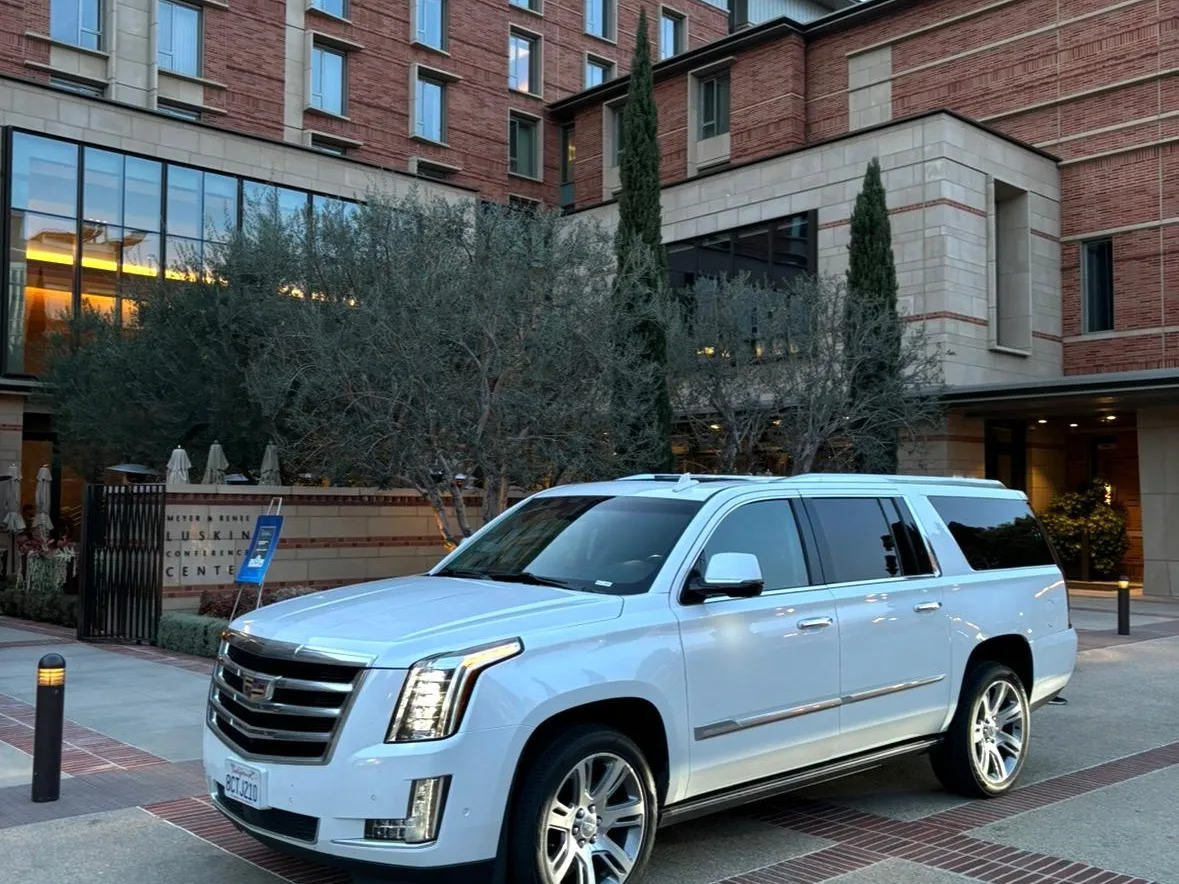 White Cadillac Escalade ESV parked at the Meyer and Renee Luskin Conference Center at UCLA at dusk